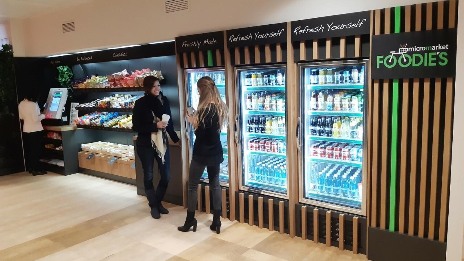 Two women browsing a large multi-unit micro-market setup
